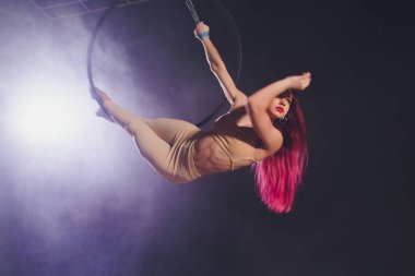 Hava acrobat içinde belgili tanımlık çalmak. Genç bir kız akrobatik öğeleri hava ringde gerçekleştirir..