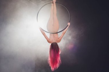 Hava acrobat içinde belgili tanımlık çalmak. Genç bir kız akrobatik öğeleri hava ringde gerçekleştirir..