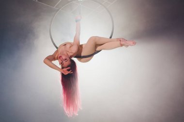 Hava acrobat içinde belgili tanımlık çalmak. Genç bir kız akrobatik öğeleri hava ringde gerçekleştirir..