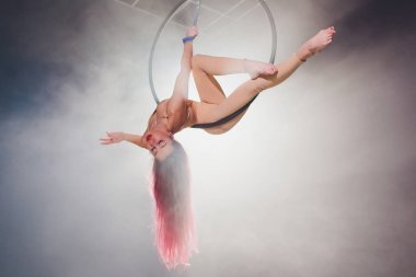 Hava acrobat içinde belgili tanımlık çalmak. Genç bir kız akrobatik öğeleri hava ringde gerçekleştirir..