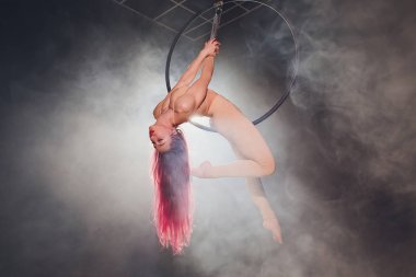 Hava acrobat içinde belgili tanımlık çalmak. Genç bir kız akrobatik öğeleri hava ringde gerçekleştirir..