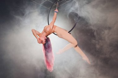 Hava acrobat içinde belgili tanımlık çalmak. Genç bir kız akrobatik öğeleri hava ringde gerçekleştirir..