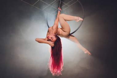 Hava acrobat içinde belgili tanımlık çalmak. Genç bir kız akrobatik öğeleri hava ringde gerçekleştirir..