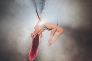 Hava acrobat içinde belgili tanımlık çalmak. Genç bir kız akrobatik öğeleri hava ringde gerçekleştirir..