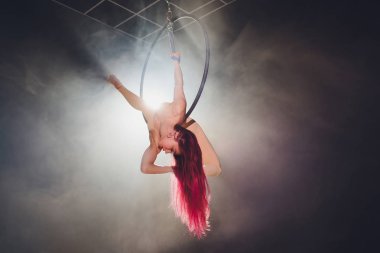 Hava acrobat içinde belgili tanımlık çalmak. Genç bir kız akrobatik öğeleri hava ringde gerçekleştirir..