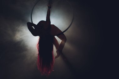 Hava acrobat içinde belgili tanımlık çalmak. Genç bir kız akrobatik öğeleri hava ringde gerçekleştirir..