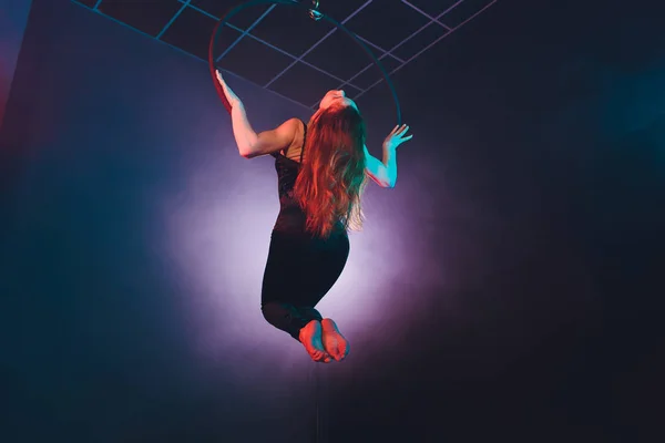 Acróbata aérea en el ring. Una chica joven realiza los elementos acrobáticos en el anillo de aire . — Foto de Stock