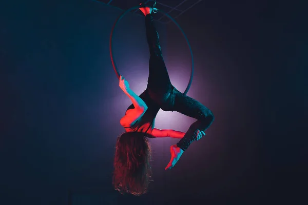 Acróbata aérea en el ring. Una chica joven realiza los elementos acrobáticos en el anillo de aire . — Foto de Stock