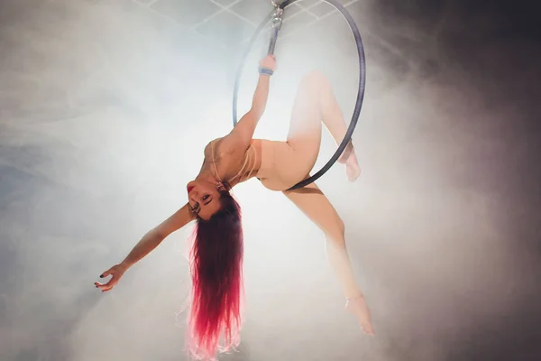 Aerial acrobat in the ring. A young girl performs the acrobatic elements in the air ring. — Stock Photo, Image