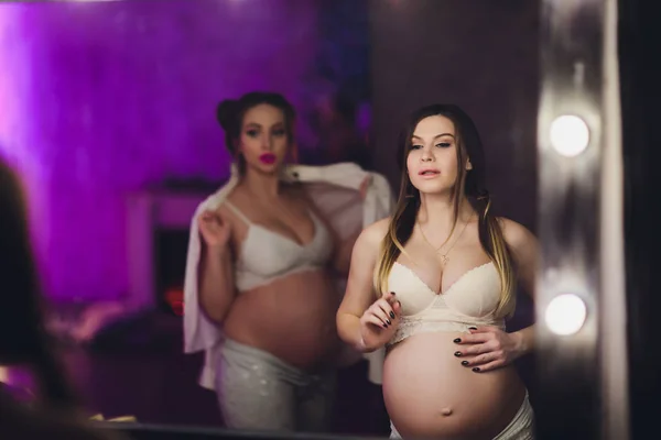 Duas amigas grávidas estão esperando por seus filhos mostrando barriga . — Fotografia de Stock