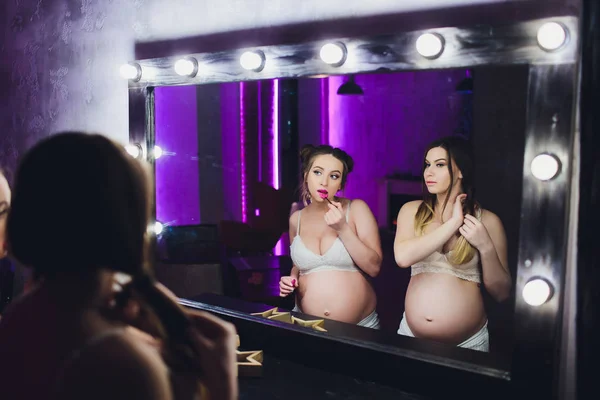 Duas amigas grávidas estão esperando por seus filhos mostrando barriga . — Fotografia de Stock