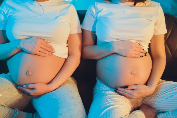 Duas amigas grávidas estão esperando por seus filhos mostrando barriga . — Fotografia de Stock