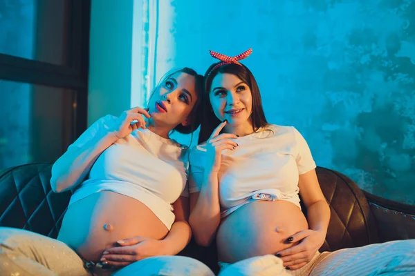 Dva těhotné přátele čekají na své děti, které vykazují břicho. — Stock fotografie