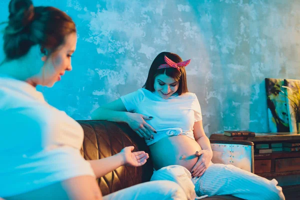 Duas amigas grávidas estão esperando por seus filhos mostrando barriga . — Fotografia de Stock