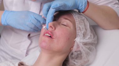 Doktor kozmetik uzmanı güzellik salonunda güzel bir kadının dudak büyütme prosedürünü yapıyor. Kozmetik cilt bakımı..