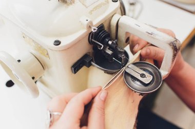Ev yapımı dikiş makinesinin bakımını yapan kadın eller..