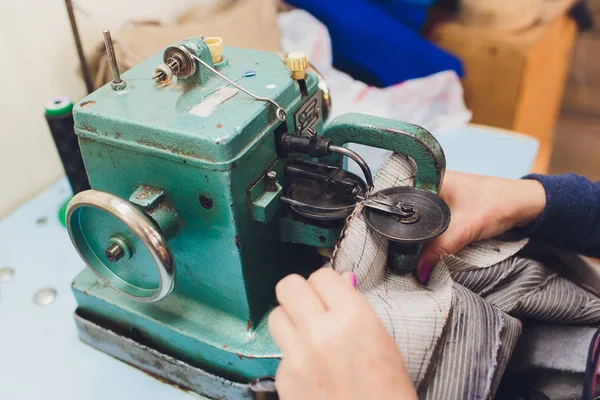 Ev yapımı dikiş makinesinin bakımını yapan kadın eller..