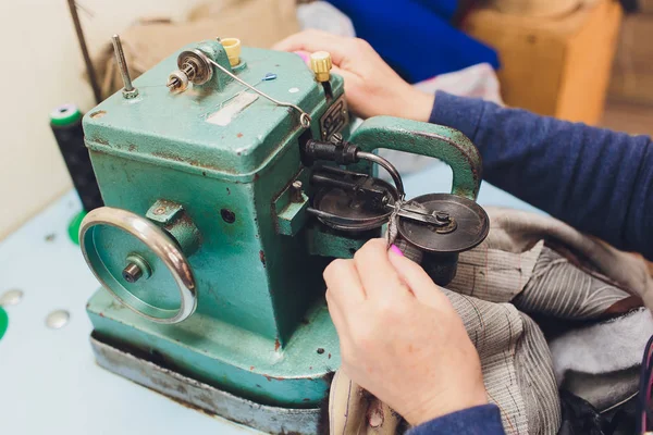 Female hands doing maintenance work on a domestic sewing machine.