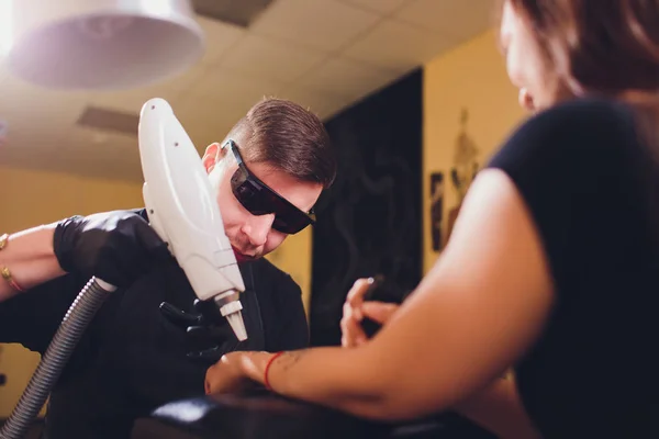 Cosmetoloog met patiënt en professionele tatoeage verwijderen laser in salon. — Stockfoto