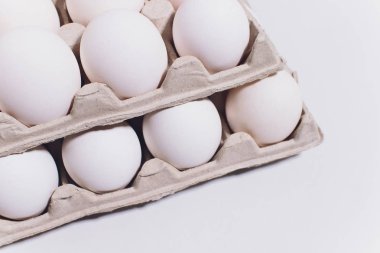 Zararsız bir tavuk beyaz yumurta, beyaz bir arka planda karton ambalaj. 2 paket.