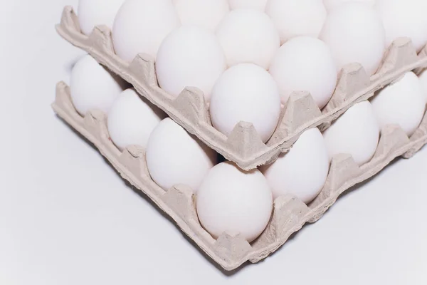 Białe jaja kura w nieszkodliwe, kartonowe opakowanie na białym tle. 2 plecaki. — Zdjęcie stockowe