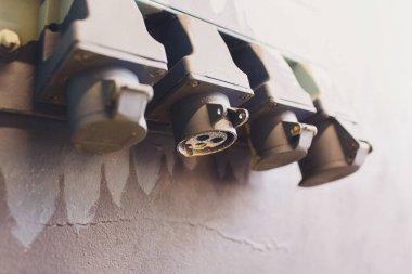 Rustik ve Vintage elektrik: bina stüdyosunda gri kirli çimento duvarında çelik boru ile ışık anahtarları seti.