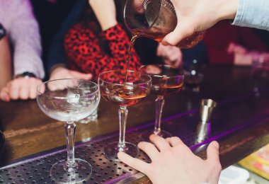 Erkek barmen kokteyl dökme alkol arka plan bar cam için shaker yapıyor. Barmen iş başında.