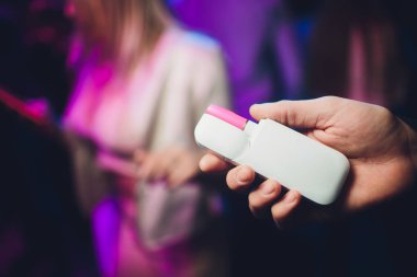 Elektronik Sigara, teknoloji sigara. Tütün sistemi ıqos erkek el restoranın bulanık arka planda. pembe durumda. Lgbt.