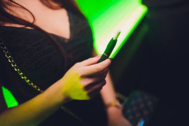 Elektronik Sigara, teknoloji sigara. Tütün sistemi Iqos. Restoran bulanık arka planda kadın el. siyah kasa.