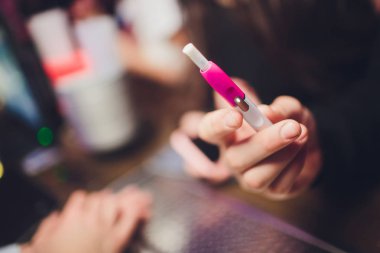 Elektronik Sigara, teknoloji sigara. Tütün sistemi ıqos erkek el restoranın bulanık arka planda. pembe durumda. Lgbt.