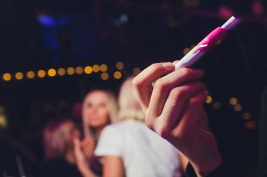 Elektronik Sigara, teknoloji sigara. Tütün sistemi ıqos erkek el restoranın bulanık arka planda. pembe durumda. Lgbt.