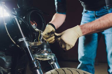 Adam bisikleti onariyor. Onun garajına yakın motosiklet tamir emin genç adam. Far içinde yedek lamba