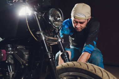 Adam bisikleti onariyor. Onun garajına yakın motosiklet tamir emin genç adam. Kaliper, fren balatası değişimi