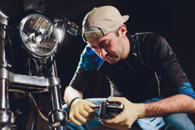 Adam bisikleti onariyor. Onun garajına yakın motosiklet tamir emin genç adam. Kaliper, fren balatası değişimi