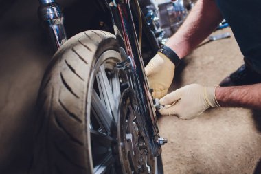 Adam bisikleti onariyor. Onun garaj yakınında motosiklet tamir emin genç adam.