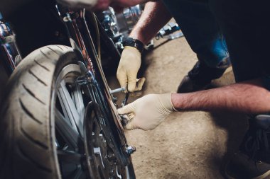 Adam bisikleti onariyor. Onun garaj yakınında motosiklet tamir emin genç adam.