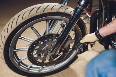 Adam bisikleti onariyor. Onun garaj yakınında motosiklet tamir emin genç adam.