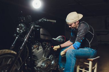 Adam bisikleti onariyor. Onun garaj yakınında motosiklet tamir emin genç adam.