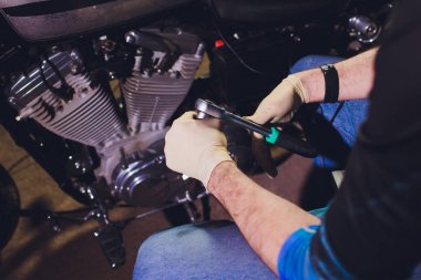 Adam bisikleti onariyor. Onun garaj yakınında motosiklet tamir emin genç adam.