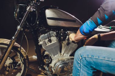 Adam bisikleti onariyor. Onun garaj yakınında motosiklet tamir emin genç adam.