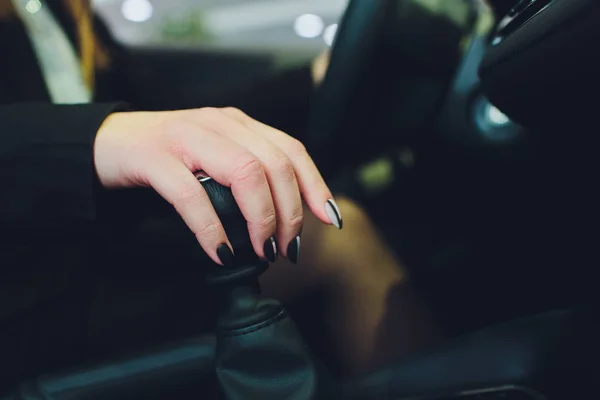 車のギアボックスのレバーの上の女性の手。マニュアルトランスミッション。女性の自立, スキル, 平等. — ストック写真