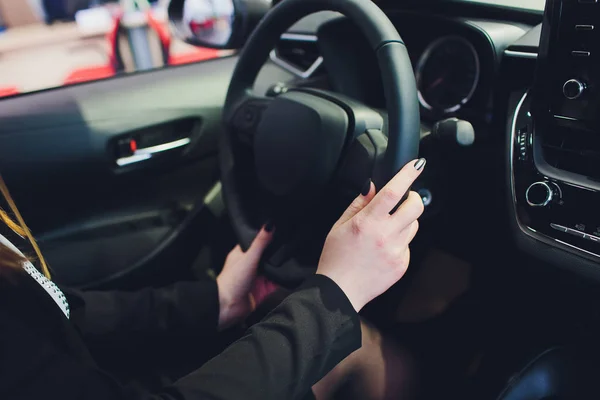 Vrouw het besturen van een auto, handen op het stuurwiel close-up. — Stockfoto