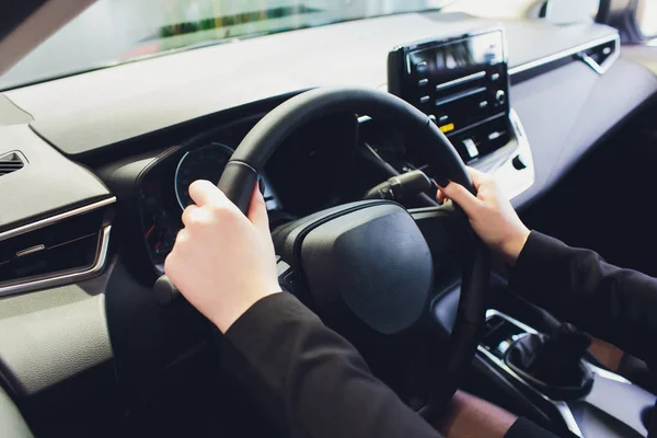 stock image Woman driving a car, hands on steering wheel close-up.