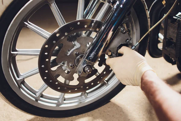 Hombre arreglando bicicleta. Joven confiado reparando motocicleta cerca de su garaje . — Foto de Stock