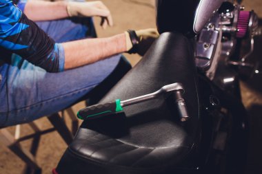 Adam bisikleti onariyor. Onun garaj yakınında motosiklet tamir emin genç adam.