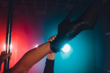 yüksek topuklu ayakkabılarla sahnede striptiz gece kulübü, kutup dans hareket genç striptiz dansçısı.