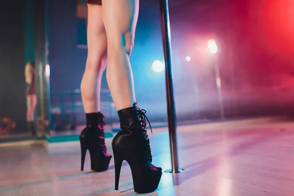 young striptease dancer moving in high heels shoes on stage in strip night club, Pole dancing.