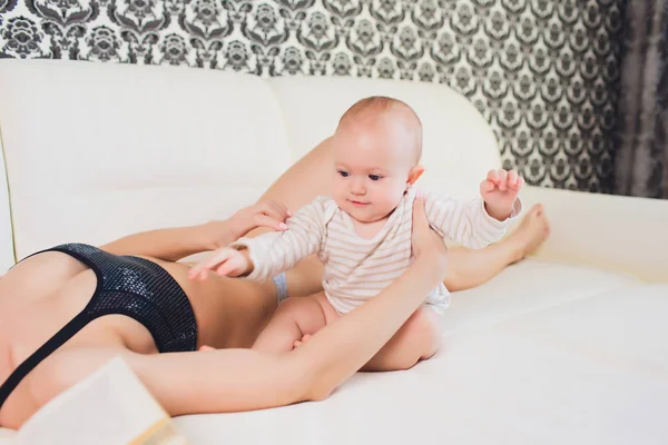 A Mother and baby child on a white bed. — Stock Photo, Image