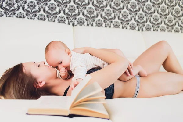 A Mother and baby child on a white bed. — Stock Photo, Image