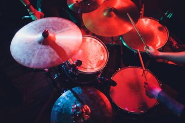 Davulcu sahnede konserde davul çalıyor. Müzik şovu. Kulüpte parlak sahne ışıkları, ellerinde davul sopaları..